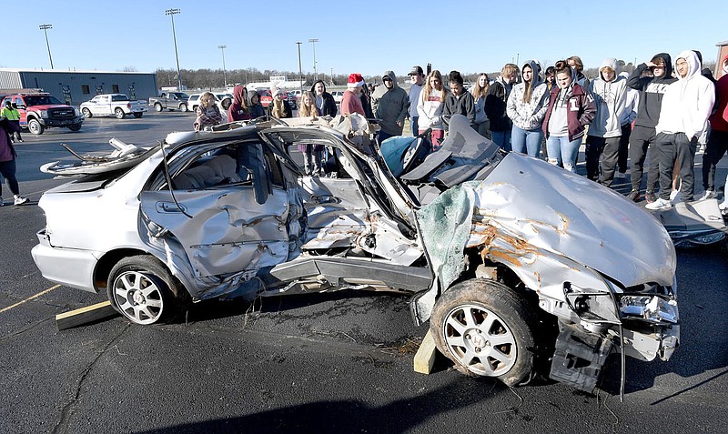 ANDY SHUPE NWA DEMOCRAT-GAZETTE
Lincoln High School students look at a wrecked car after Prairie Grove Fire Department firefighters cut it open during a hands-on demonstration and exposition for local rescue personnel on Dec. 15, 2022, at Lincoln High School.