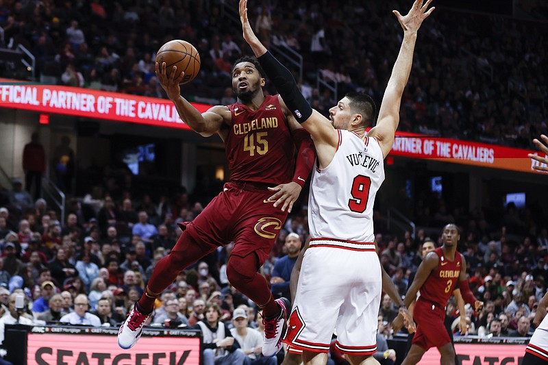 Cleveland Cavaliers guard Donovan Mitchell (45) shoots against Chicago Bulls center Nikola Vucevic (9) during the second half of an NBA basketball game, Monday, Jan. 2, 2023, in Cleveland. (AP Photo/Ron Schwane)