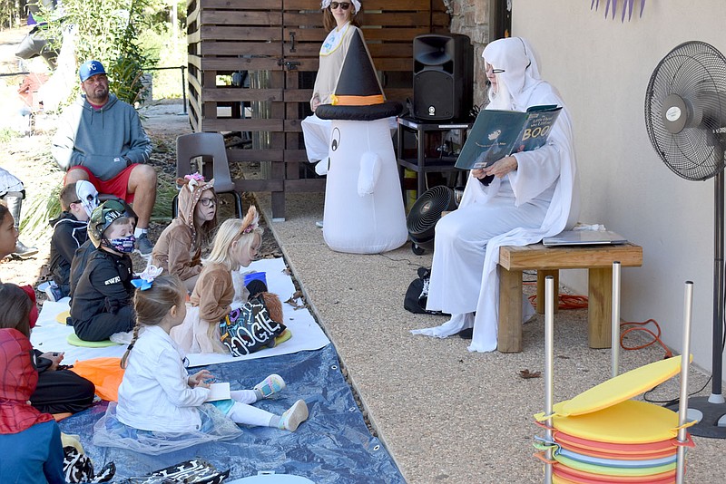 File photo "Granny Boo" (right) reads a Halloween story to children during "Treat Street" at the Bella Vista Public Library in 2021. "Treat Street" was one of many programs for children provided at the library, which is now offering several new programs.