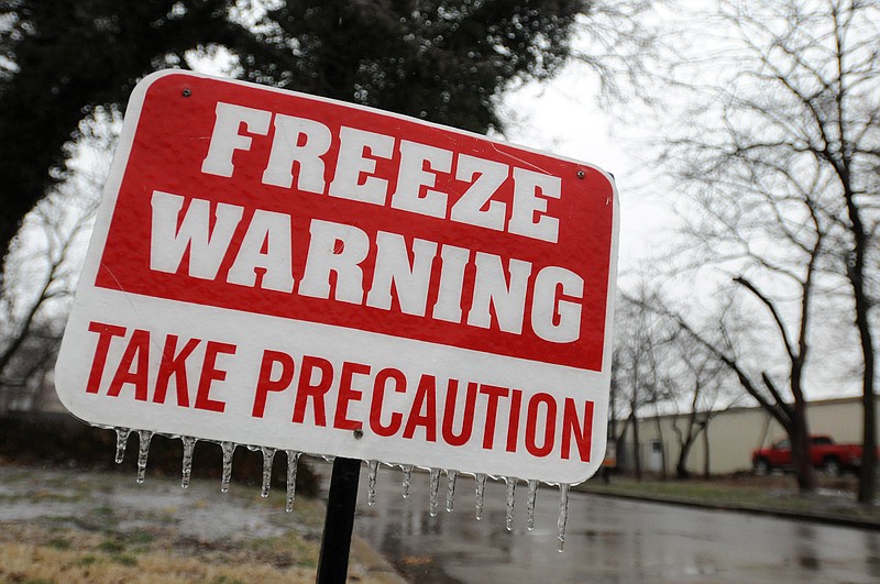 A sign warning residents of freezing temperatures is coated with a layer of ice Feb. 21, 2013, at the Del Mar Apartments in Bentonville. (File Photo/NWA Democrat-Gazette)