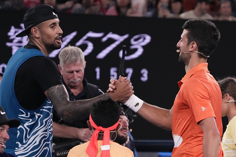 El australiano Nick Kyrgios y el serbio Novak Djokovic se saludan tras un duelo de exhibición en la Arena Rod Laver en Melbourne, Australia el viernes 13 de enero del 2023. (AP Foto/Mark Baker)