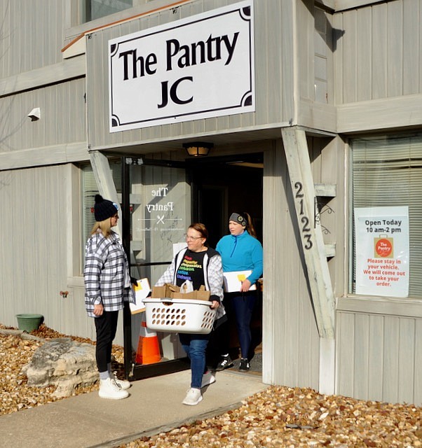 Joe Gamm/News Tribune photo: 
Lisa Peterson (from left to right) holds a door open for Karen Sholes and Carrie Watkins. Sholes carries The Pantry JC orders to clients waiting in cars. Watkins goes car-to-car to collect orders.