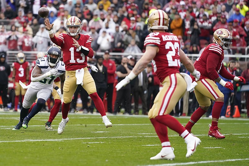 San Francisco 49ers quarterback Brock Purdy (13) throws touchdown pass to running back Christian McCaffrey (23) in front of Seattle Seahawks linebacker Bruce Irvin (51) during the first half of an NFL wild card playoff football game in Santa Clara, Calif., Saturday, Jan. 14, 2023. (AP Photo/Godofredo A. Vásquez)