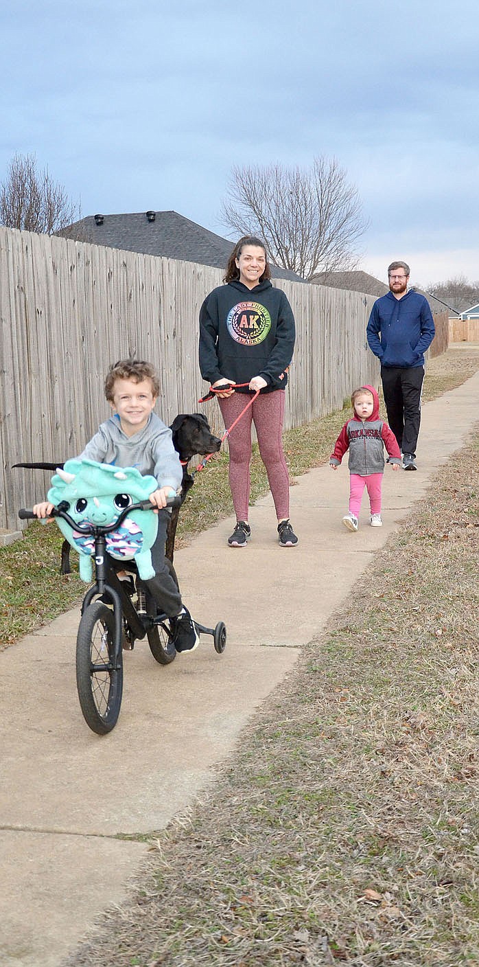 TIMES photograph by Annette Beard
Sunday afternoon's mild temperatures provided a good opportunity for a walk (and ride) around the neighborhood in Standing Oaks for Kaytlyn and Brandon Bulen, their children Oliver, 5, and Gracie, 2, and dog, Mason.