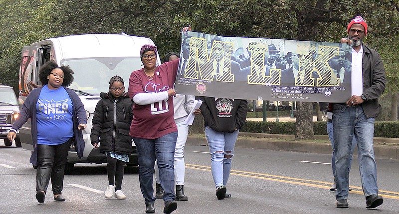 Representatives of Union Missionary Baptist Church carry a sign with an image of Martin Luther King Jr. leading the march from Selma, Ala., to Montgomery, Ala., during the Martin Luther King Day Parade in downtown Hot Springs Monday. - Photo by Donald Cross of The Sentinel-Record
