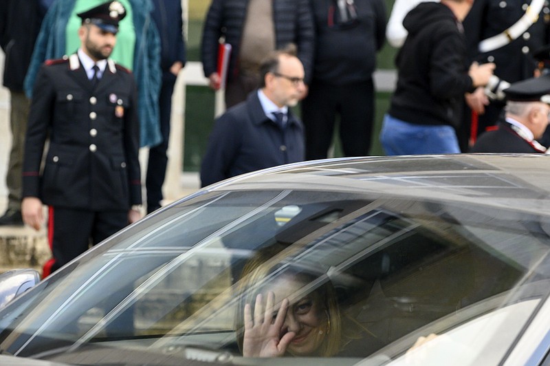 Italian Premier Giorgia Meloni waves to journalists upon her arrival at the Palace of Justice in Palermo, Sicily, Monday, Jan. 16, 2023. Italy's No. 1 fugitive, convicted Mafia boss Matteo Messina Denaro, was captured on Monday at a private clinic in Palermo, Sicily, after three decades on the run. (AP Photo/Valeria Ferraro)