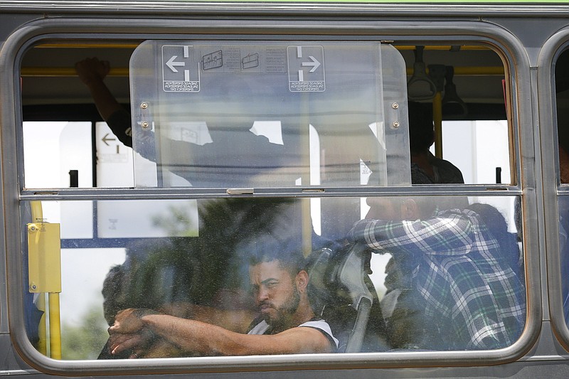 Supporters of former Brazilian President Jair Bolsonaro who were arrested after the storming of public buildings are taken by bus to a federal prison as they leave the Federal Police Academy in Brasilia, Brazil, Wednesday, Jan. 11, 2023. (AP Photo/Gustavo Moreno)