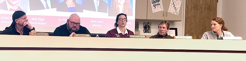 Lake Hamilton School Board Secretary Tiffany McCain, center, asks Hill and Cox Construction President Brian Hill, in the audience, a question during Tuesday night’s monthly board meeting at the district administration building. - Photo by Donald Cross of The Sentinel-Record