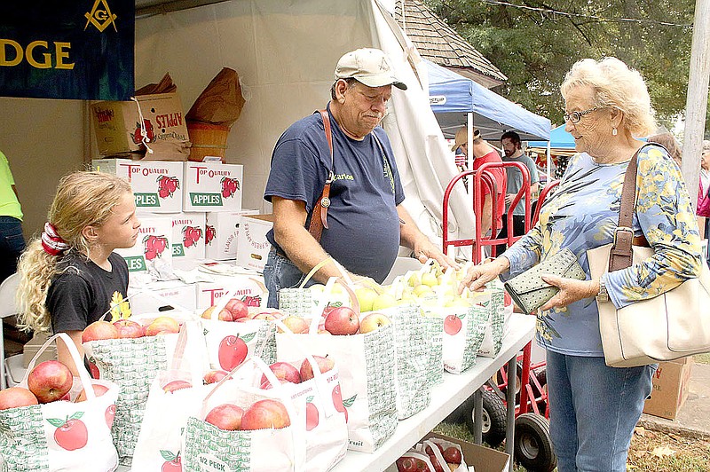 File Photo
Betty Payne of Jasper purchases a bag of apples from Carlos Reed with the Lincoln Masonic Lodge during the 2021 Arkansas Apple Festival. The 2023 festival has been canceled because the community building is closed and unsafe for occupancy.