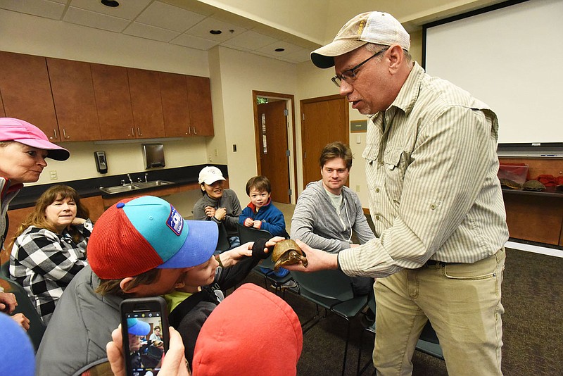 NWA Democrat-Gazette/FLIP PUTTHOFF 
OUT OF ITS SHELL
Chris Pistole, interpreter at Hobbs State Park-Conservation Area, lets visitors on Saturday March 23 2019 feel the shell of a box turtle during his program on reptiles at the park. Pistole also brought a speckled king snake for visitors to touch.