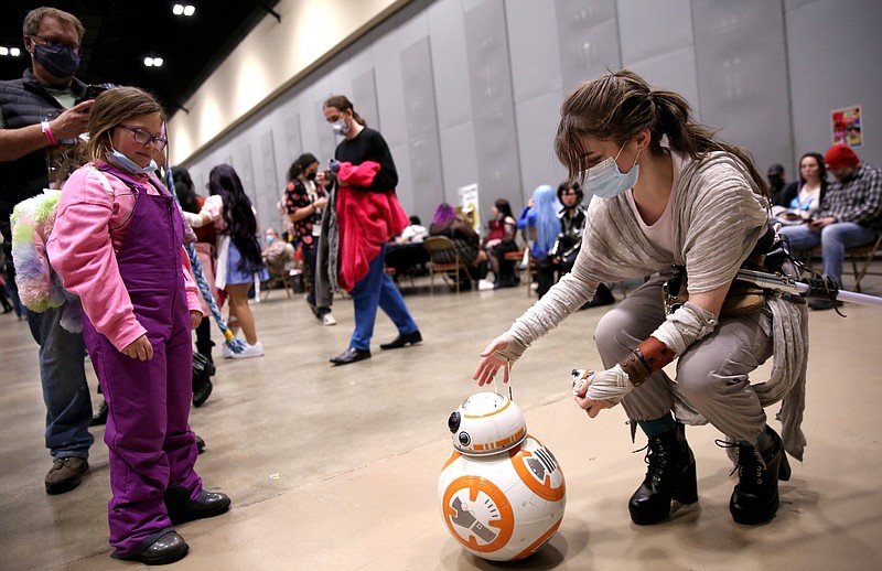 Kraine Brun (right), dressed as Rey from the "Star Wars" films, adjusts a remote-control BB-8 replica at the first Little Rock Anime Festival, Feb. 5, 2022, at Little Rock's Statehouse Convention Center. (Democrat-Gazette file photo/Colin Murphey)
