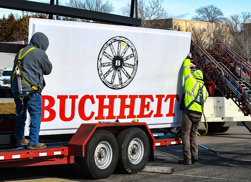 Julie Smith/News Tribune photo: 
Bobby Blackburn, at left, and Jared Goble unload the large panel from it's rack on the trailer as they prepare to hoist it to its new home in the sign frame in the front of the lot at Buchheit, formerly Orscheln Farm and Home. The Orscheln stores were purchased last year by Tractor Supply Company but if there already was a Tractor Supply in close proximity, those Orschelns were sold to Buchheit. This crew at Columbia Sign Service has been changing out to the Buchheit signage at several stores in the mid-Missouri area.