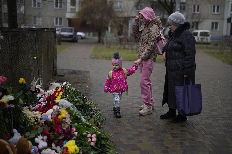 Gente rinde homenaje en el lugar donde cayó un helicóptero el miércoles en Brovary, en las afueras de Kiev, Ucrania, viernes 20 de enero de 2023. (AP Foto/Daniel Cole)