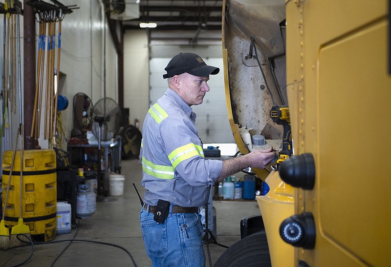 Second Shift Lead Mechanic Curtis Clark performs routine maintenance on a school bus, Friday, January 20, 2023 at the Bentonville Schools bus barn in Bentonville. The Bentonville School Board is scheduled to hold a work session Thursday with two topics on the agenda. One is “transportation sustainability.” The administration would like to review the growth of the transportation department and how to continue supporting the department with the district’s growth. Visit nwaonline.com/photos for today's photo gallery.

(NWA Democrat-Gazette/Charlie Kaijo)