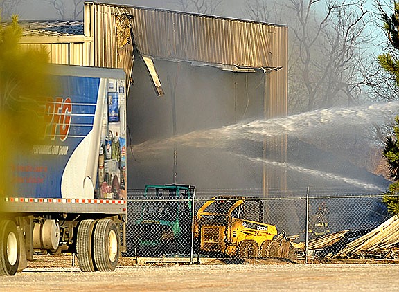 Firefighters from Lowell, Bethel Heights and Springdale spray down a fire at USA Metal on 721 S. Lincoln St. in Lowell in December 2013. USA Metal Recycling has appealed the revocation of its conditional use permit to the Benton County Circuit Court. 
(File photo/NWA Democrat-Gazette/Michael Woods)