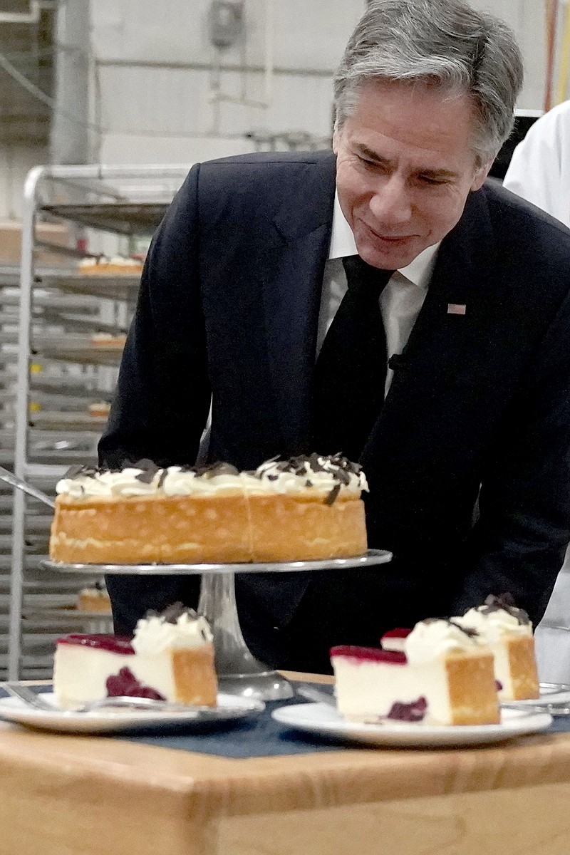 U.S. Secretary of State Antony Blinken, looks over a cheesecake at The Eli's Cheesecake Company during a visit Friday, Jan. 20, 2023, in Chicago. Blinken applauded the Chicago based company for their commitment to hiring refugees and immigrants. (AP Photo/Charles Rex Arbogast)
