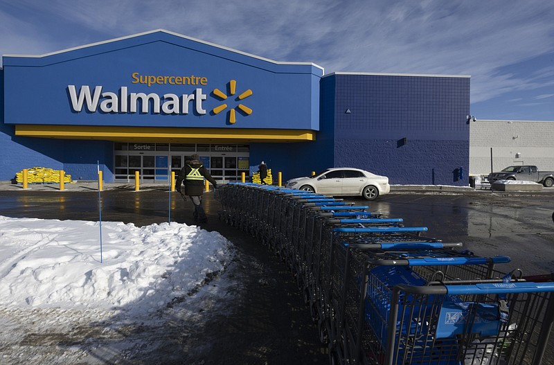 A worker pulls shopping carts outside a Walmart store in Montreal, Quebec, Canada, on Monday, Jan. 24, 2022. Premier Franois Legault announced that residents will have to show their vaccination passport starting today to enter stores with floor surfaces of 1,500 square meters or more. MUST CREDIT: Bloomberg photo by Christinne Muschi