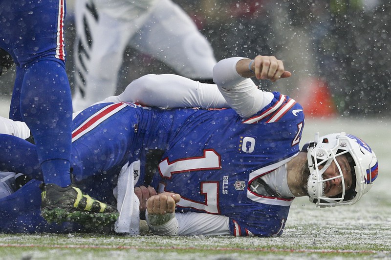 Buffalo Bills quarterback Josh Allen (17) takes a hit after making a pass against the Cincinnati Bengals during the first quarter of an NFL division round football game, Sunday, Jan. 22, 2023, in Orchard Park, N.Y. (AP Photo/Joshua Bessex)