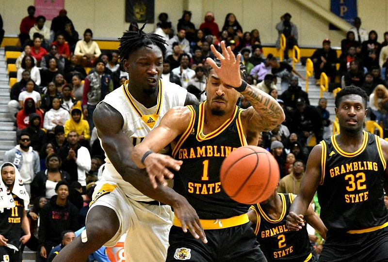 Ismael Plet of UAPB and Cameron Christon of Grambling State battle for a loose ball in the first half Monday at H.O. Clemmons Arena. (Pine Bluff Commercial/I.C. Murrell)
