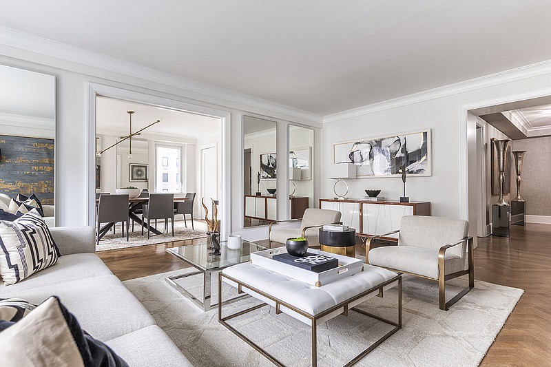 An ottoman is paired with a coffee table to create a second table option in this living room. (Handout/TNS)