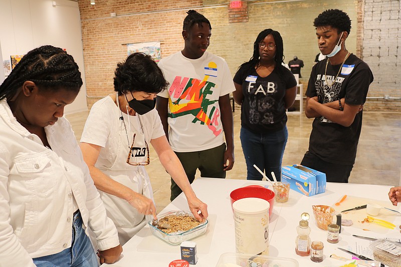 Faith Anaya (second from left) teaches cooking skills and techniques to Pine Bluff area youngsters in the CrEATe Lab at the Arts & Science Center for Southeast Arkansas. (Special to the Democrat-Gazette)