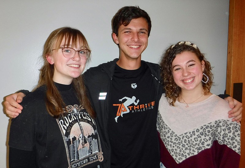 Susan Holland/Westside Eagle Observer Members of the thespian group at Gravette High School flash big smiles after giving their presentation at the Gravette School Board meeting Monday evening, Jan. 23. Madison Lovell (left), Ethan Strecker and Skyler Hernandez told about their classes in drama and theater and their future plans. Ethan has recently produced a short film. School board members gave approval for them to attend the state thespian competition.