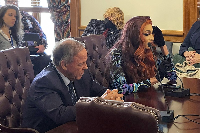 Drag performer MD Hunter, whose stage name is Athena Sinclair, testifies before a state Senate panel as state Sen. Gary Stubblefield, left, listens, at the Arkansas Capitol in Little Rock, Ark., on Thursday, Jan. 19, 2023. The Senate panel endorsed a bill by Stubblefield that would restrict where drag performances can be shown by classifying them as adult oriented businesses. (AP Photo/Andrew DeMillo)