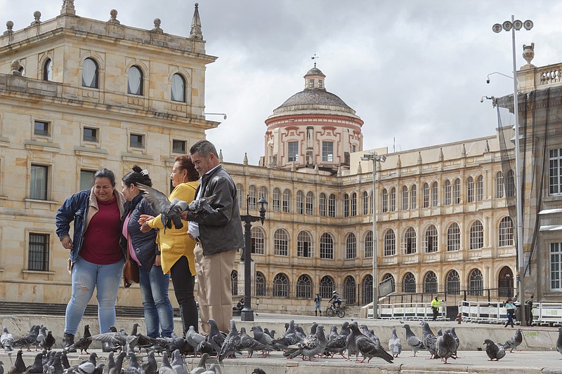 A family of tourists is surrounded by pigeons while posing for pictures in the middle of Bolivar Square in Bogota, Colombia. (Alejandro Bernal/Dreamstime/TNS)