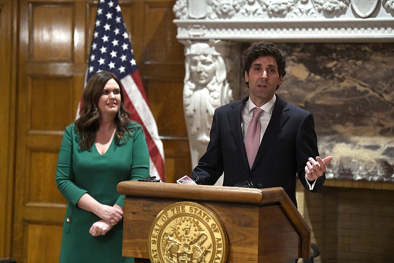 Arkansas Gov. Sarah Huckabee Sanders, left, listens as her husband, Bryan Sanders, answers questions during a news conference Tuesday at the state Capitol. - Arkansas Democrat-Gazette/Stephen Swofford