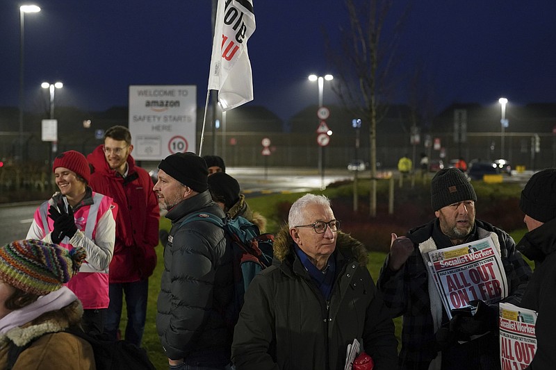 Members of the GMB union stand on the picket line outside the Amazon fulfillment centre, as Amazon workers stage their first ever strike in the UK in a dispute over pay, in Coventry, England, Wednesday, Jan. 25, 2023. (Jacob King/PA via AP)