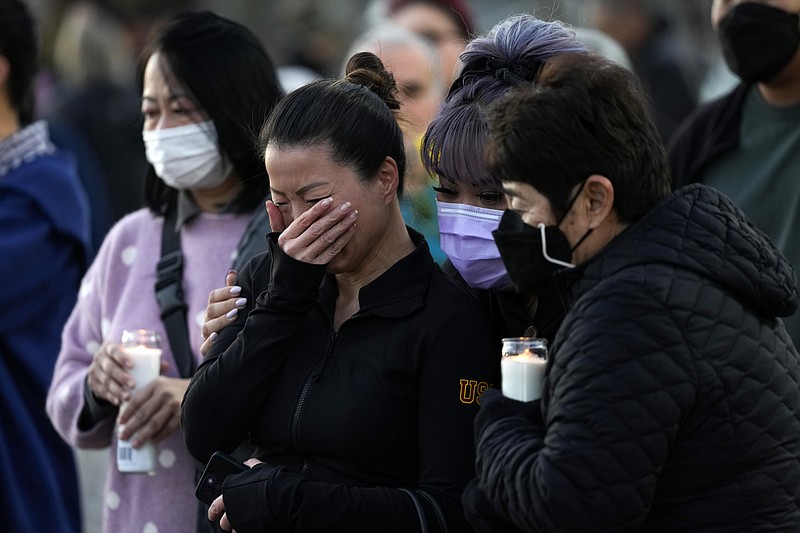 People attend a vigil outside Monterey Park City Hall, blocks from the Star Ballroom Dance Studio on Tuesday, Jan. 24, 2023, in Monterey Park, Calif. A gunman killed multiple people at the ballroom dance studio late Saturday amid Lunar New Years celebrations in the predominantly Asian American community. (AP Photo/Ashley Landis)