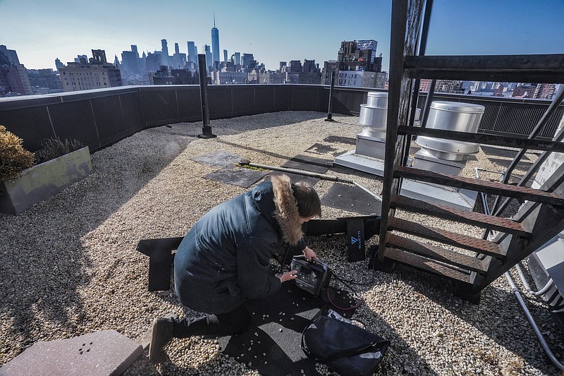 Josh Spodek setup a portable solar kit on the rooftop of his Greenwich Village apartment building to charge his phone and laptop, Tuesday Jan. 24, 2023, in New York. Spodek's efforts to go packaging-free changed his mindset and led him to reduce his electrical consumption to near zero. &quot;I want to show people this is possible, that this is desirable, that we'd only wish we had done it earlier.&quot; (AP Photo/Bebeto Matthews)