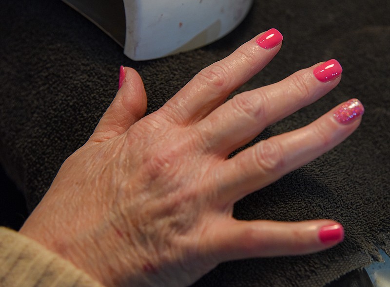 Julie Smith/News Tribune
Bethannie Moore of Polished Nail Salon by Kim performs the multi-step process of removing the acrylic nails, filing and cutting the exisitng nails then applying polish for a customer.