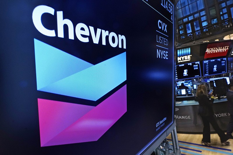 FILE - The logo for Chevron appears above a trading post on the floor of the New York Stock Exchange on Nov. 1, 2021. Shares of Chevron climbed Thursday, Jan. 26, 2023, after the oil company announced that it would repurchase $75 billion of its stock. (AP Photo/Richard Drew, File)