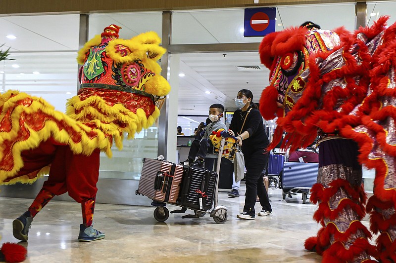 Dragon and Lion dance performers welcome Chinese tourists arriving at the Ninoy Aquino International Airport in Manila on Tuesday, Jan. 24, 2023. The expected resumption of group tours from China is likely to bring far more visitors. (AP Photo/Gerard V. Carreon)