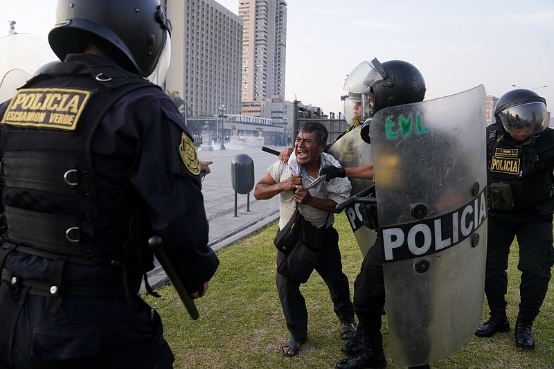 Un policía detiene a un manifestante de oposición al gobierno en Lima, Perú, el jueves 26 de enero de 2023. Las protestas buscan un adelanto electoral inmediato, la renuncia de Boluarte, la liberación del presidente destituido Pedro Castillo y justicia por los manifestantes muertos en enfrentamientos con la policía. (AP Foto/Martín Mejía)