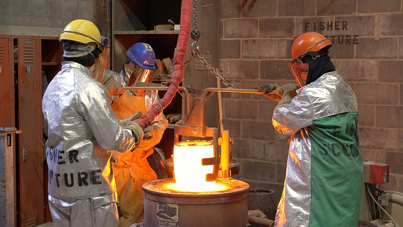 Workers in the Pennsylvania foundry at Fisher Sculpture lift a crucible of molten bronze out of the kiln before pouring sections of the statue of Babe Ruth that will sit at the entrance of Majestic Park in this image taken from video released by Visit Hot Springs Friday. The sculpture will be unveiled in a public ceremony on Feb. 6. - Submitted photo