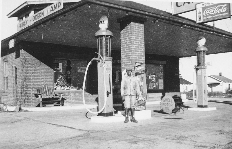 Photo courtesy Kingdom of Callaway Historical Society
Sam Wilkerson stands in front of Muir's Modern Camp in 1936. Wilkerson worked for W. Cecil Muir at the Service Station and lived in their basement. Cabins can be seen in the background behind Wilkerson.