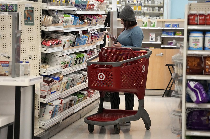 A shopper checks out an item in a Target store in Pittsburgh on Monday, Jan. 23, 2023. On Friday, the Commerce Department issues its December report on consumer spending. (AP Photo/Gene J. Puskar)