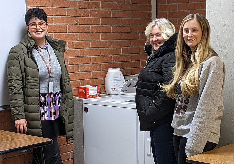 Randy Moll/Westside Eagle Observer
School counselors Natasha McFeeters (left), Dea Ann Heinen and Hannah Davis stand in front of a washer and dryer in a new facility for use by homeless students and their families to do laundry. The school counselors at each campus were instrumental in making the new service available and will be the contact persons for students to access the facility.