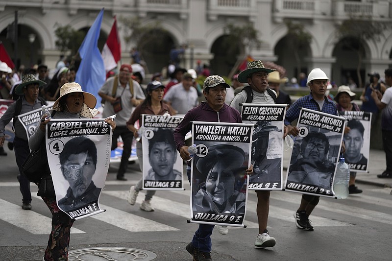 Anti-government protesters march with posters showing images of the more than 40 people who have died during clashes with police amid the country's unrest, in Lima, Peru, Saturday, Jan. 28, 2023. Protesters are seeking immediate elections, President Dina Boluarte's resignation, the release of ousted President Pedro Castillo and justice for protesters killed in clashes with police. (AP Photo/Martin Mejia)