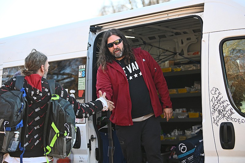 Aaron Reddin, founder of The Van, shakes hands with Ron Ostrandei after giving him new clothes and supplies Thursday, Jan. 27, 2023 along England Road in North Little Rock.
(Arkansas Democrat-Gazette/Staci Vandagriff)
