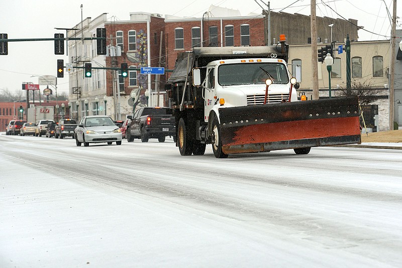 A snow plow and other traffic travels in sleet on Wednesday, Feb. 23, 2022, along Towson Avenue in Fort Smith. (NWA Democrat-Gazette FILE PHOTO/Hank Layton)