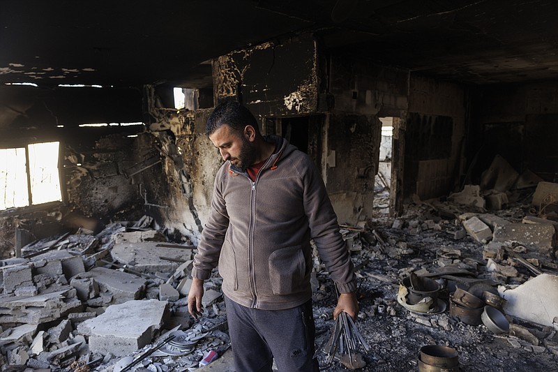 A Palestinian man looks at a house Friday that was damaged by explosives in Jenin camp in the West Bank. MUST CREDIT: Photo for The Washington Post by Kobi Wolf