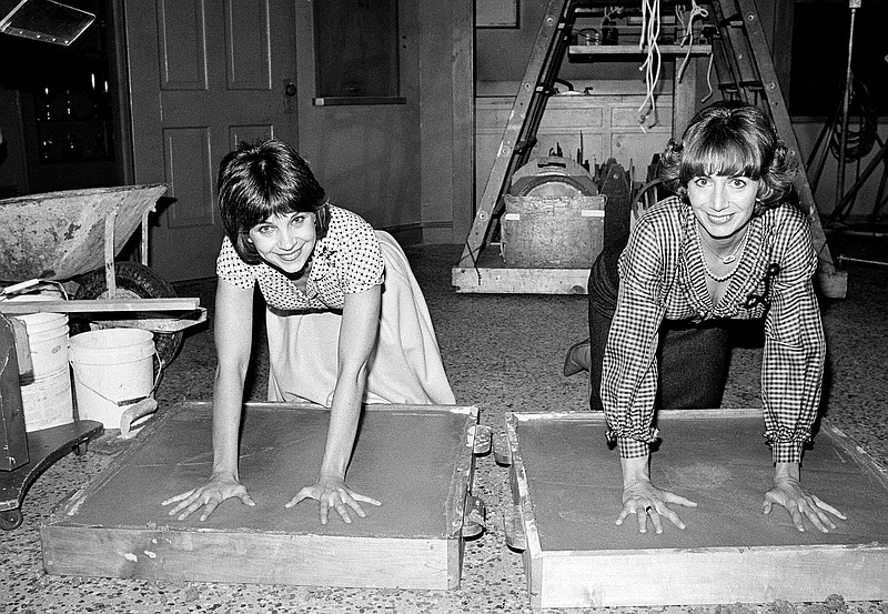 FILE - Actors Cindy Williams, left, and Penny Marshall, stars of the ABC-TV comedy series "Laverne and Shirley," make an impression in cement after the taping of their show in Los Angeles, on Nov. 14, 1979. Williams, who was among the most recognizable stars in America in the 1970s and 1980s for her role as Shirley opposite Marshall's Laverne on the beloved sitcom, died Wednesday, Jan. 25, 2023, in Los Angeles at age 75, after a brief illness, her family said Monday, Jan. 30.  (AP Photo/Lennox McLendon, File)