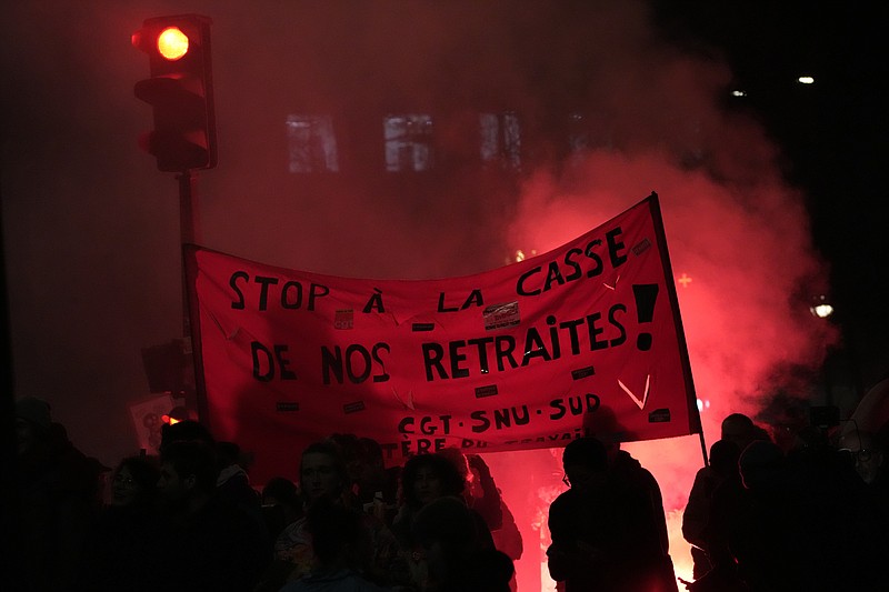 Protesters hold a banner demanding to stop plans to push back France's retirement age, during a demonstration against Tuesday, Jan. 31, 2023 in Paris. Labor unions aimed to mobilize more than 1 million demonstrators in what one veteran left-wing leader described as a "citizens' insurrection." The nationwide strikes and protests were a crucial test both for President Emmanuel Macron's government and its opponents. (AP Photo/Christophe Ena)