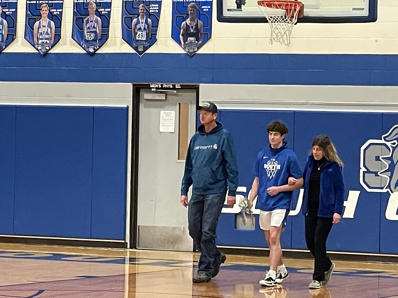 South Callaway's JT Thomas walks to halfcourt with his parents to be recognized on Senior Night, as the Bulldogs took on Show-Me Conference rival Russellville Tuesday night at South Callaway High School in Mokane.