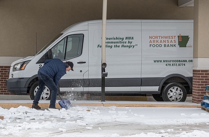 Eddie Kordsmeier, director of facilities for the Northwest Arkansas Food Bank, works Wednesday to clear the parking lot of the organization's Feed Rogers food pantry on 13th Street in Rogers. The pantry is not open because it runs on the same schedule as Rogers schools. Once the schools reopen, so will the pantry.

(NWA Democrat-Gazette/Spencer Tirey)