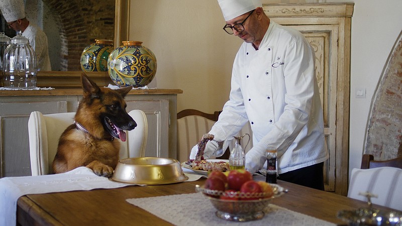 Gunther the wealthy German shepherd is served steak by a member of his staff in the Netflix docuseries “Gunther’s Millions,” now streaming. (Netflix)
