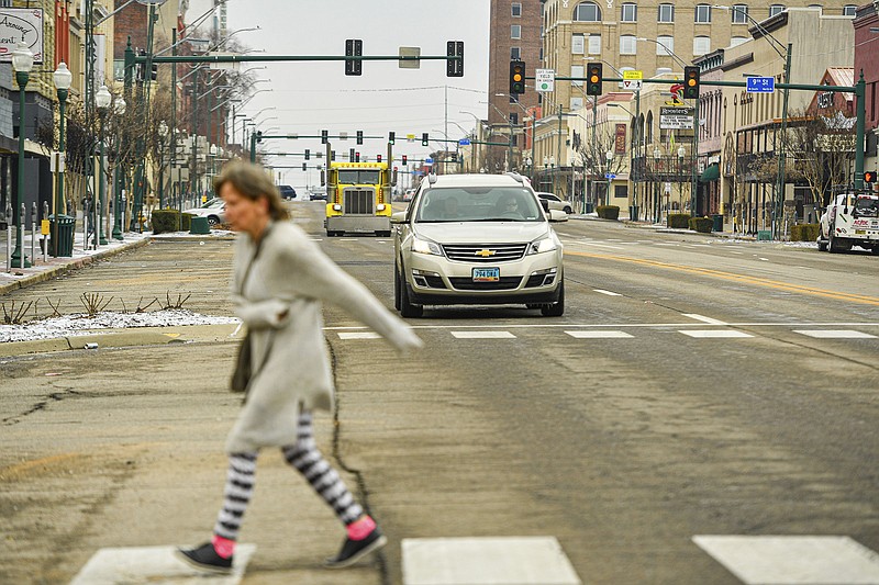 Traffic waits at a red light as a woman crosses Garrison Avenue on Wednesday in downtown Fort Smith.  Visit nwaonline.com/photo for today's photo gallery.

(River Valley Democrat-Gazette/Hank Layton)